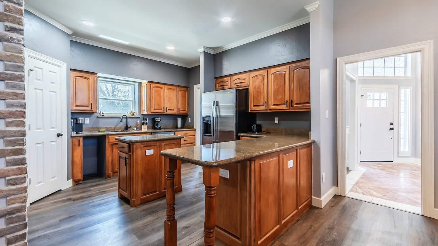 Open kitchen with wood cabinetry, a large center island and stainless steel appliances